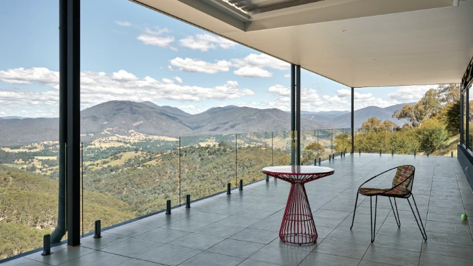 A patio with a table and chairs overlooking mountains
